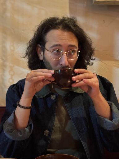 Avi Goldman drinking from a small cup